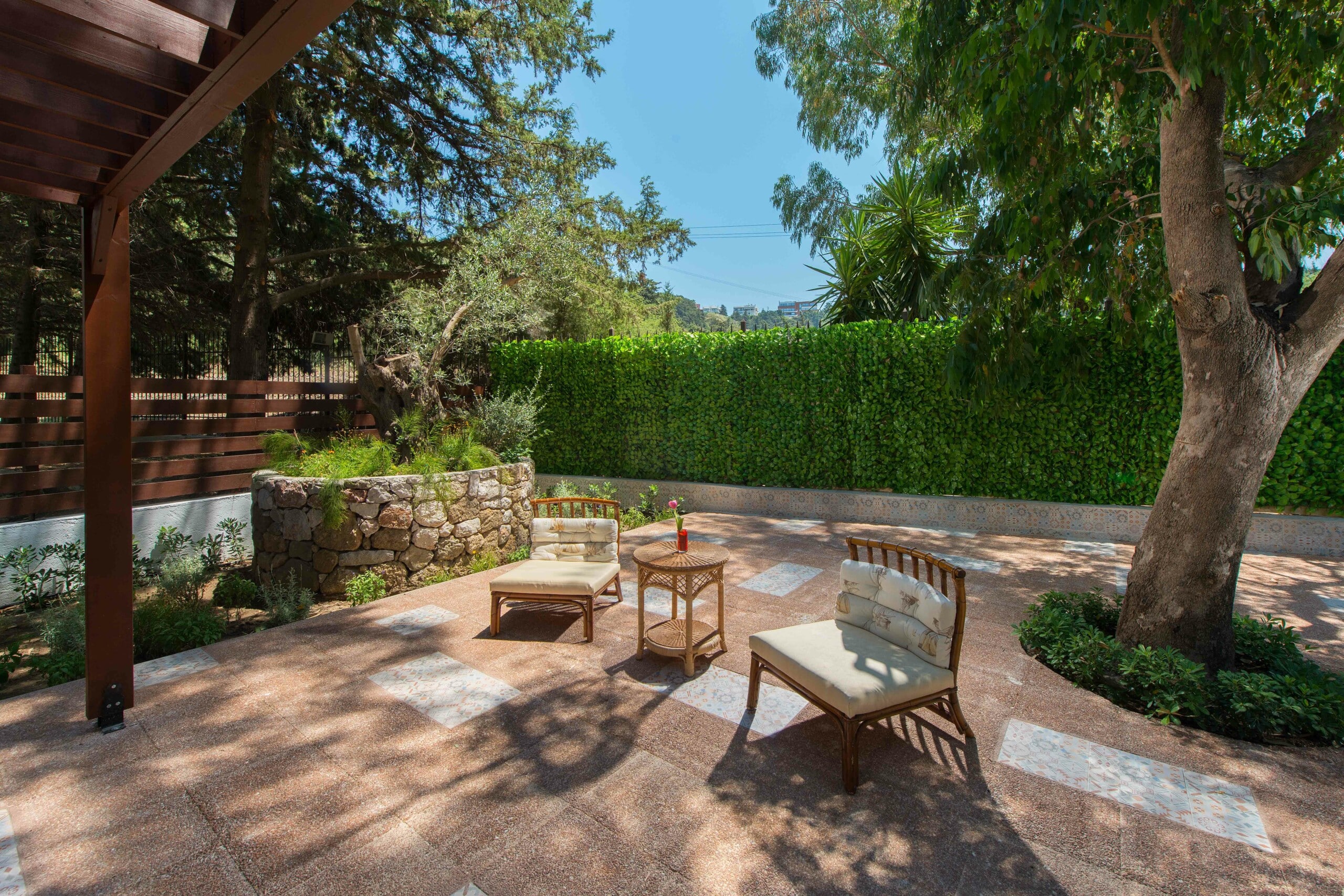 Outdoor space with chairs and garden at Dionysos Hotel's Deluxe Bungalow.