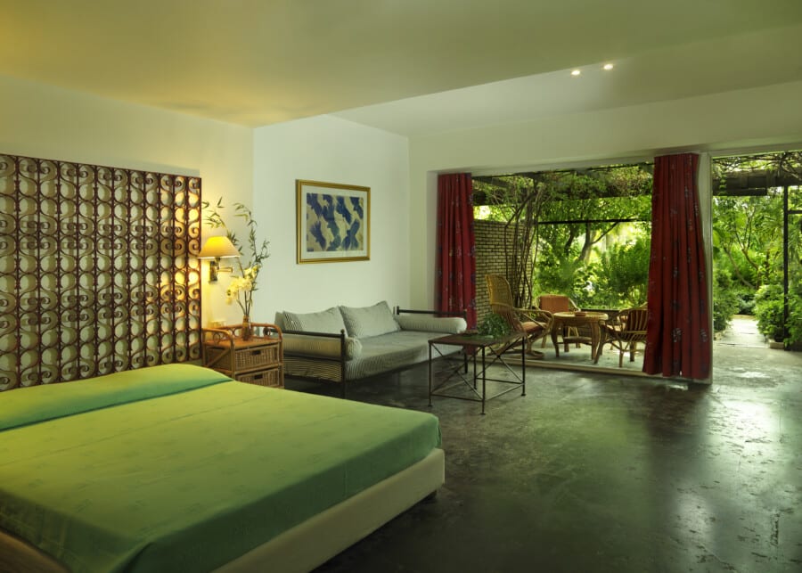 Photo displaying the bed and outdoor terrace of the Garden Studio at Dionysos Hotel.