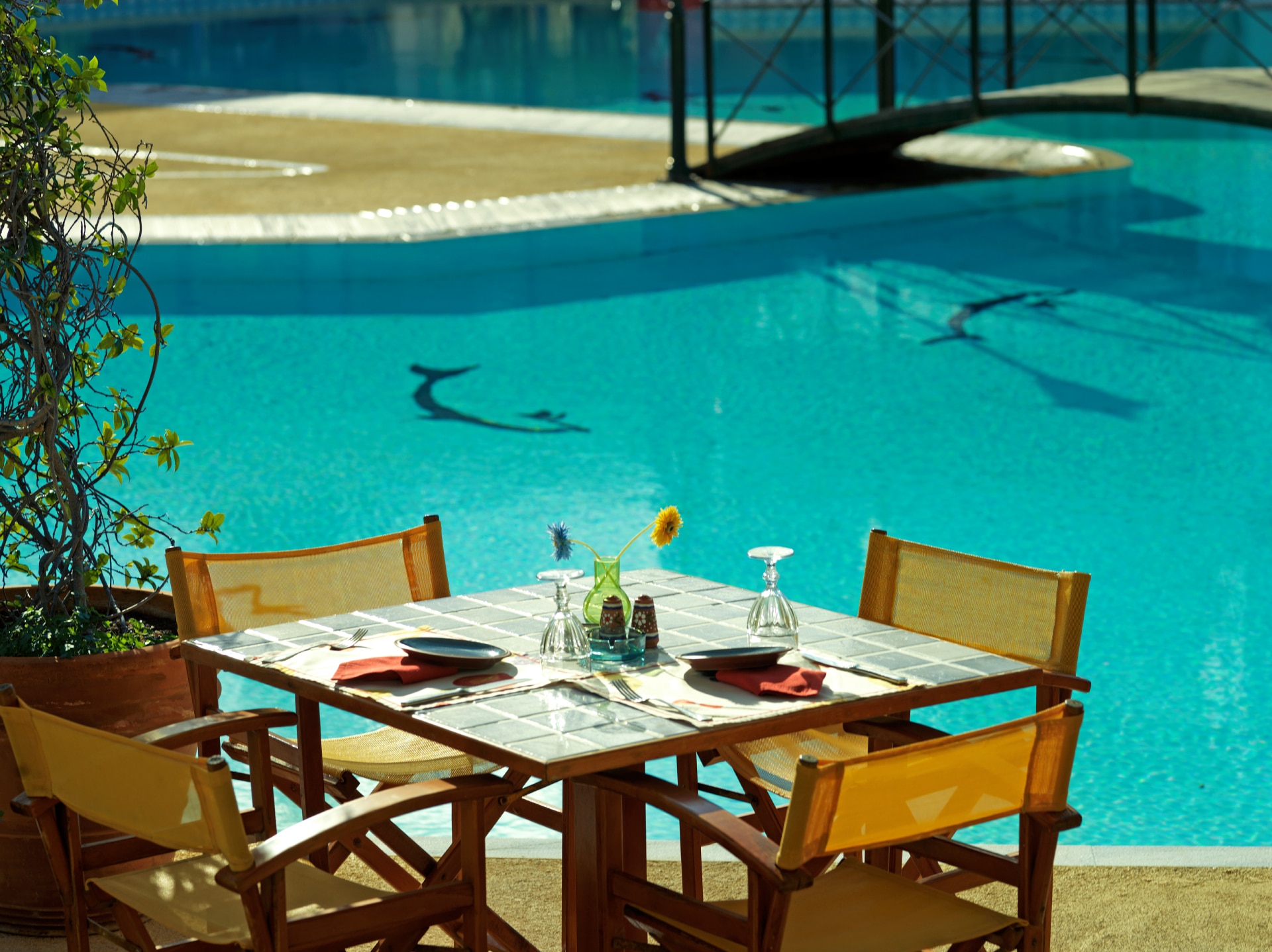 Ένα όμορφα διαμορφωμένο τραπέζι στον υπαίθριο χώρο δίπλα στην πισίνα του εστιατορίου Maistros Pool